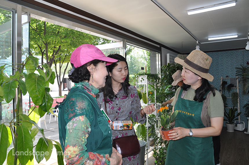 정원지원센터 홍보관을 찾은 시민이 시민정원사들에게 식물 상담을 받고 있다.