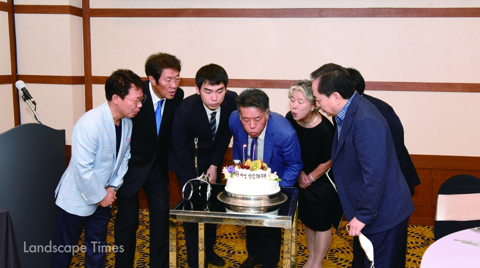 1.권오병 아썸 대표(중앙)와 회사 관계자, 축하를 위해 참석한 인사들이 기념 케이크 촛불을 소화하고 있다.