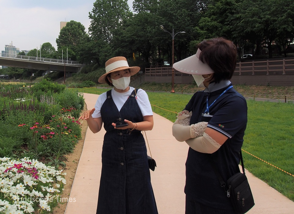 (사진 왼쪽)정원설계 및 시공을 자문한 김승민 더봄 대표가  탄천 정원을 찾은 주민에게 식물에 대해 설명하고 있다.