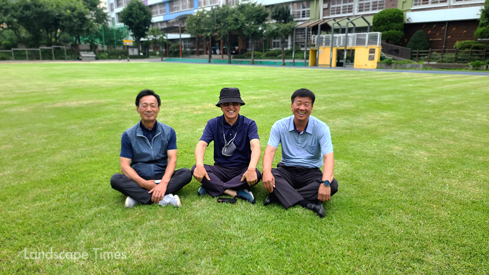 (좌측부터) 이완영 프리터프 이사 이성호 엘그린잔디 대표 이정천 동답초교 선생님이 동답초교 잔디운동장에 앉아 담소를 나눴다