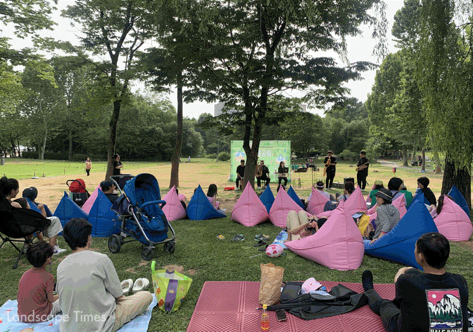 서울어린이대공원 '월간대공원' 행사에 참석한 시민들이 잔디밭에 편안하게 앉아 음악을 듣고 있다.ⓒ서울시