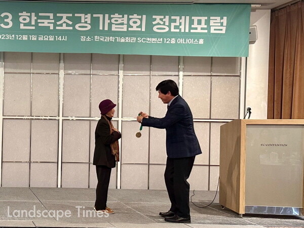 안계동 한국조경가협회 회장이 정영선 조경가에게 공로메달을  증정하고 있다.